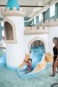 Holiday Inn Express Wisconsin Dells, an IHG Hotel في ويسكونسن ديلز: طفل صغير يركب زحليقة مائية في حديقة مائية