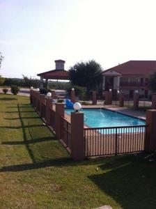 a fence around a swimming pool in a yard at Express Inn in Dallas