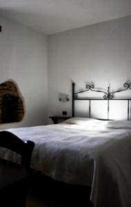 1 dormitorio con 1 cama grande con colcha blanca en Agriturismo Le Selve, en Comunanza