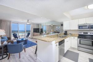a kitchen and living room with a view of the ocean at Pelican Beach Resort 308 in Destin