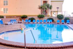 a swimming pool in a hotel with blue chairs at Nautilus 1303 in Fort Walton Beach