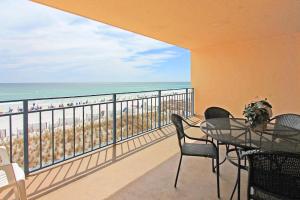 balcón con mesa y sillas y la playa en Nautilus 1303, en Fort Walton Beach