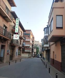 eine leere Straße mit einem Hotelschild an einem Gebäude in der Unterkunft Hotel Querol in Valderrobres