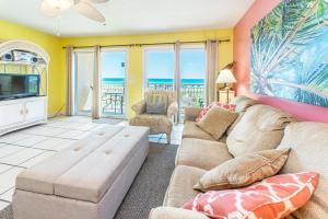 a living room with a couch and a tv at Island Sands 206 in Fort Walton Beach