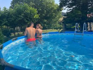 a man and a woman sitting in a swimming pool at La Solana de Mogro in Mogro