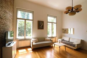 Apartment Piano Nobile, Zagreb في زغرب: غرفة معيشة مع أريكة وكرسي
