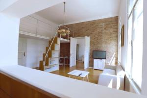 Apartment Piano Nobile, Zagreb في زغرب: غرفة معيشة بأثاث أبيض ودرج