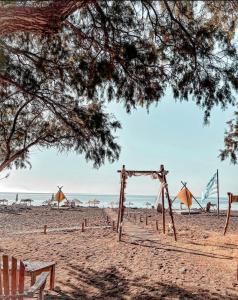 a beach with a wooden arch in the sand at Eco Beach And Magic Garden Hotel in Gennadi