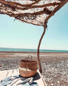 a straw hat sitting on a beach at Eco Beach And Magic Garden Hotel in Gennadi