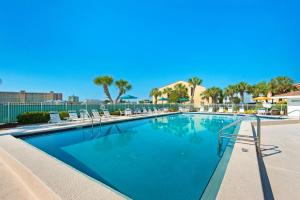 a large swimming pool with lounge chairs and umbrellas at Dolphin Point #602A in Destin