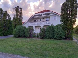 Casa bianca con balcone e cespugli di Hévízi fecskefészek a Hévíz