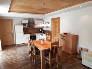 cocina y comedor con mesa de madera y sillas en Haus Sandra en Alpbach