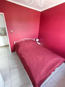 ein rotes Schlafzimmer mit einer roten Wand und einem Bett in der Unterkunft Apartament Centrum in Ustroń