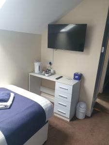 a bedroom with a bed and a tv on the wall at Leamington House in Barmouth