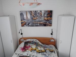 a bedroom with a bed with a poster on the wall at Loc'Eric in Pont-lʼAbbé