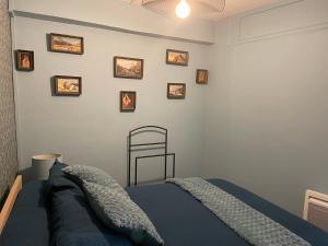 1 dormitorio con 1 cama y cuadros en la pared en LouSangla en Salies-de-Béarn