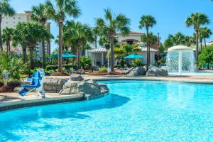 a swimming pool at a resort with palm trees at Sterling Shores 818 in Destin