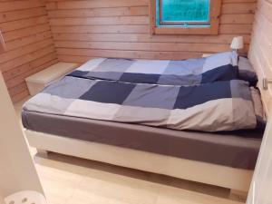 フルージルにあるDalabyggd Holiday Homeの木製の部屋にベッド1台が備わるベッドルーム1室があります。