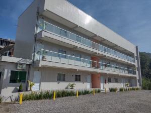 a large building with a balcony on the side of it at Apartamentos Margarida in Ubatuba