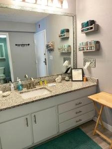 ein Badezimmer mit einem Waschbecken und einem großen Spiegel in der Unterkunft Castaways Resort Studios in Daytona Beach