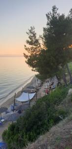 a beach with umbrellas and chairs and the ocean at Privilege in Nea Kallikrateia