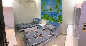 Habitación con 2 camas y una pintura en la pared. en فلل فندقية بمدينة تنومة, en Ithnayn