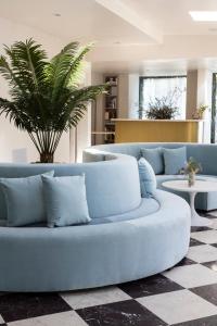 a living room with a blue couch and a palm tree at Short Stories Hotel in Los Angeles