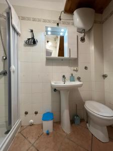 a bathroom with a sink and a toilet and a mirror at Artista studio in Cefalù +38 photos