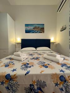 a bedroom with a bed with a blue and white blanket at Artista studio in Cefalù