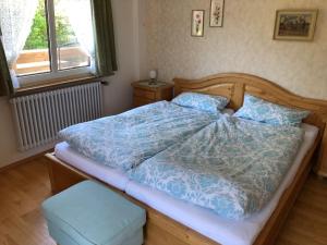 a bed with a blue comforter in a bedroom at Gästehaus Lickert Ferienwohnung Süd Feldberg in Hinterzarten