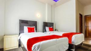 1 dormitorio con 2 camas grandes y almohadas rojas en THE TISPA SYARIAH RESIDENCE, en Palembang