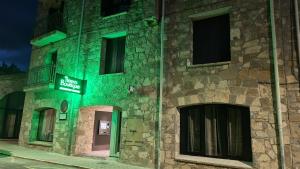 un edificio con una señal verde en el costado. en Tierra Boutique, Tierra Suites y Tierra Valles Apartamentos, en Biescas