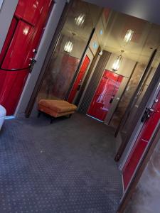 an empty hallway with red doors and a chair at Hôtel les 4 éléments in Palavas-les-Flots