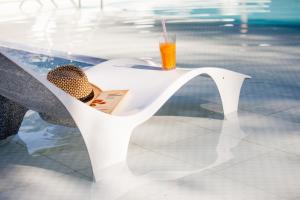 a glass of orange juice sitting on a white chair at Atelier Hotel Charme & Spa in Villa General Belgrano