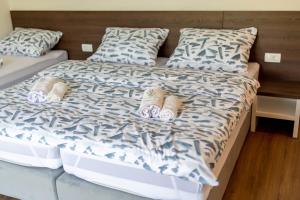 a bed with two pairs of slippers on it at Apartmani Mia in Prozor