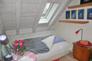 Un pequeño dormitorio con una cama y una mesa con flores en Bed and Breakfast Bavaria München, en Icking