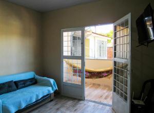 ein Wohnzimmer mit einem Sofa und einer Glasschiebetür in der Unterkunft Casa com churrasq e Wi-Fi na Praia de Itacuruca RJ in Mangaratiba