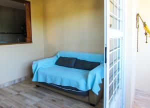 Bett in einem Zimmer mit einer blauen Decke in der Unterkunft Casa com churrasq e Wi-Fi na Praia de Itacuruca RJ in Mangaratiba