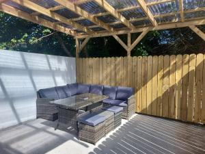 a patio with a table and chairs and a wooden fence at 8 Eyre Square Lane in Galway