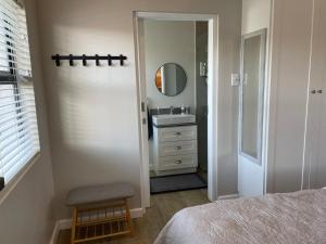 a white bathroom with a sink and a mirror at the mod pod studio in Mtunzini