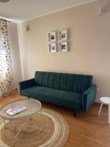 a green couch in a living room with a table at Cozy Apartment Old Town in Constanţa