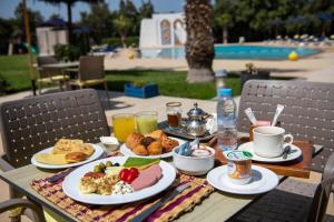 uma mesa coberta com pratos de alimentos e bebidas em Hôtel La Perle de Mogador em Essaouira