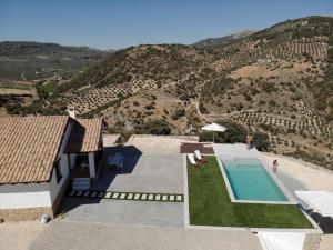 a house with a swimming pool and a mountain at CASA RURAL LA CHOZA DE MINDO in Granada