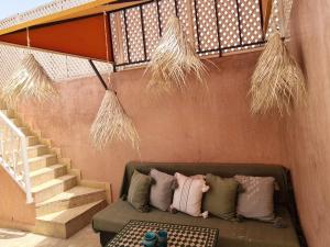eine Couch mit Kissen unter einer Treppe in der Unterkunft Riad Casa Sophia in Marrakesch