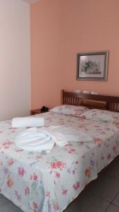 um quarto com uma cama com colcha floral em Brisa Do Vale Pousada em Itaobim