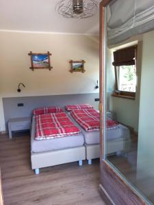 two beds in a room with a mirror at Appartamenti Elena & Milva in Livigno