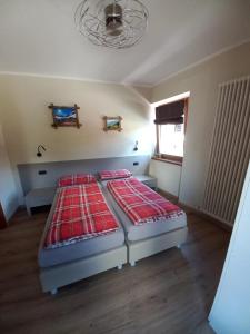 two twin beds in a room with a window at Appartamenti Elena & Milva in Livigno