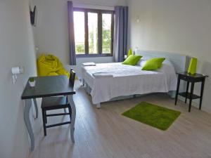 a bedroom with a bed with green pillows and a table at BcnSportHostels in Barcelona