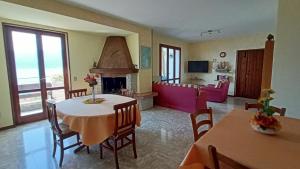 a living room with a table and chairs and a fireplace at Casa Miralago in Torri del Benaco