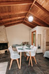 a dining room with a table and white chairs at Elenis Spiti in Moírai